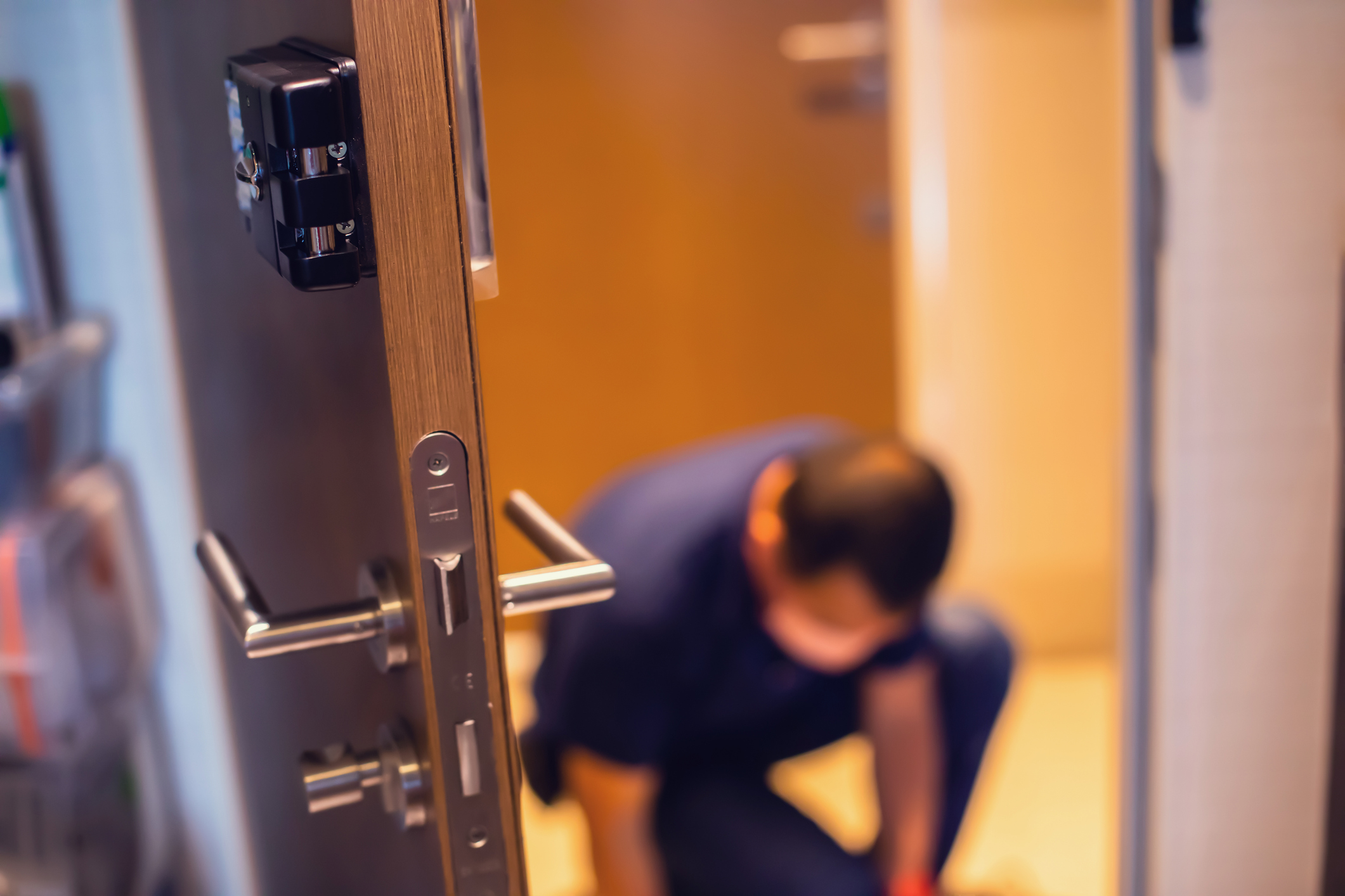 Man in a blue uniform as intercom system installers in new york city installing a system on a door