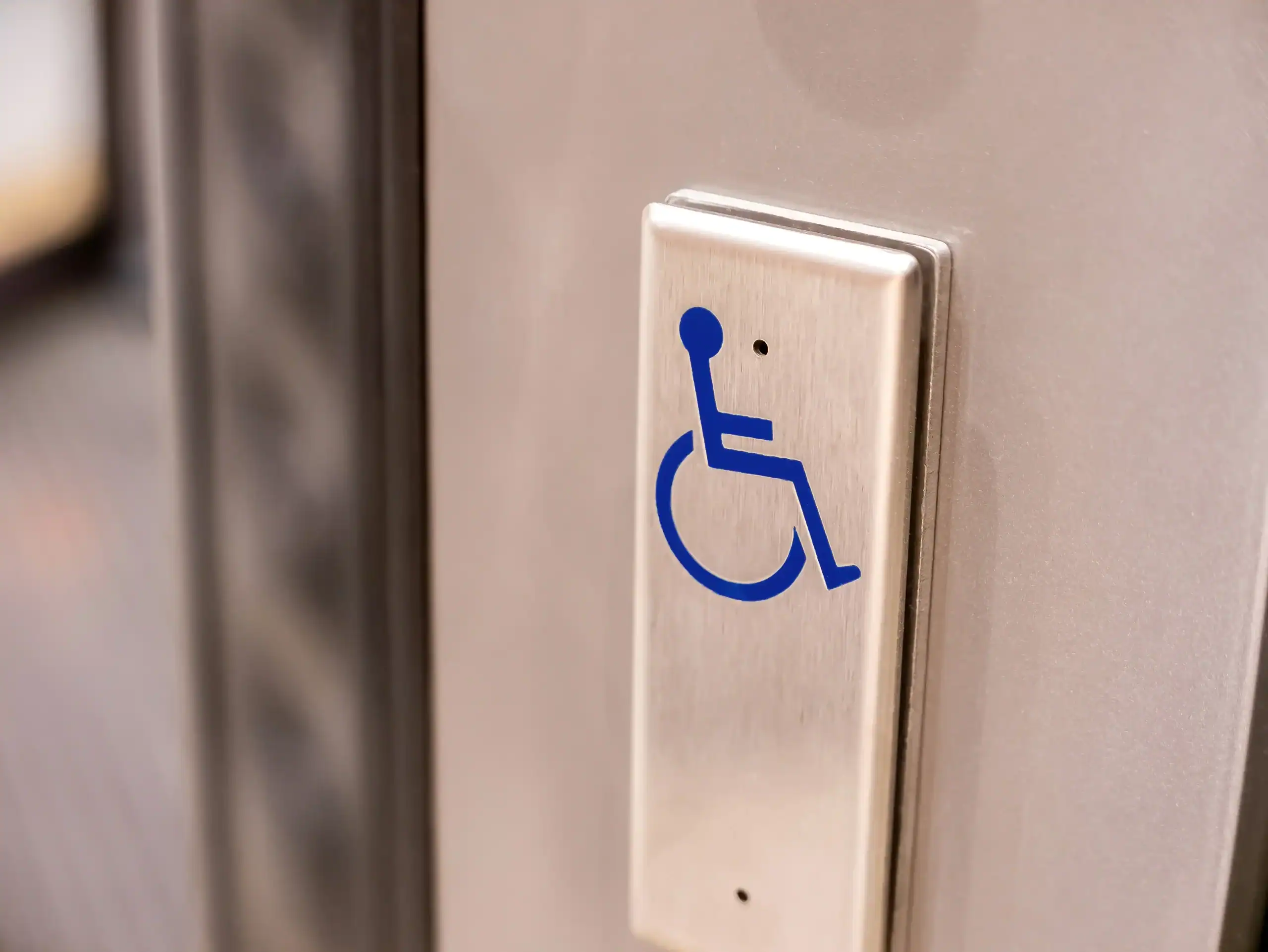 metal-button-with-blue-wheelchair-symbol-it-object-closeup-nobody-accessibility-disab metal-button-with-blue-wheelchair-symbol-it-object-closeup-nobody-accessibility-disab